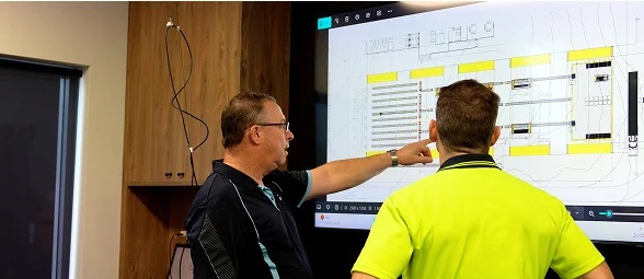 Discoverer experts reviewing a core facility CAD layout on screen